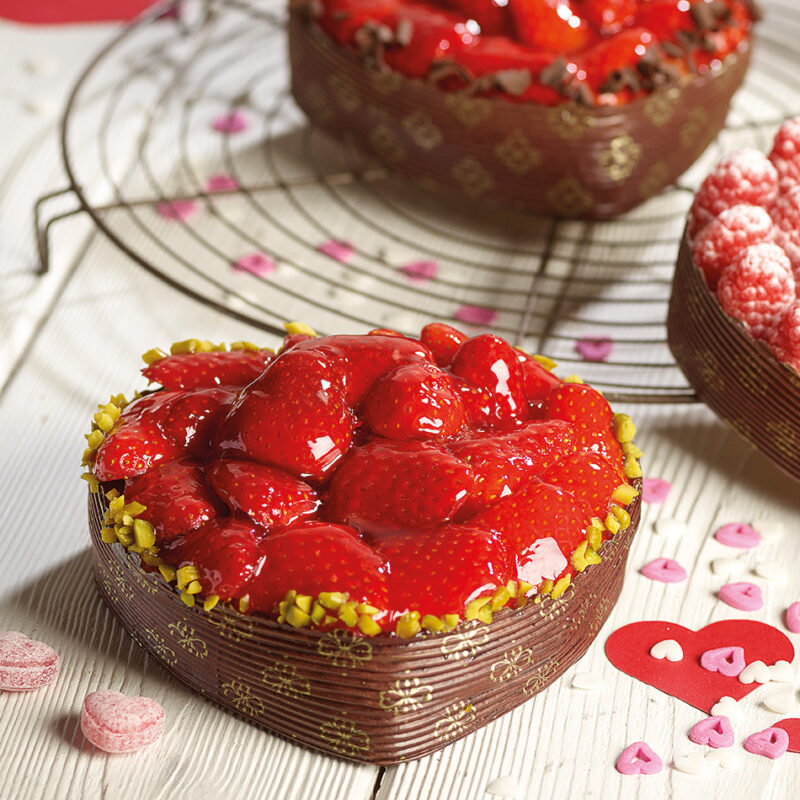 Herzkuchen mit heller Rührmasse und Erdbeeren, mit Fruchtglanz und Pistazien garniert